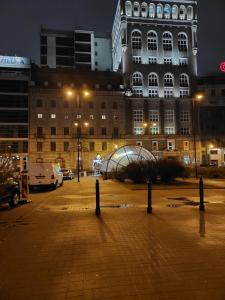 a parking lot in front of a building at night at Однокімнатна квартира Варшава in Warsaw