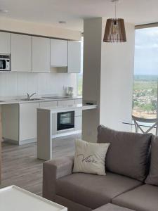sala de estar con sofá y cocina en Impactante vista al Río, moderno y con cochera! en Santa Fe