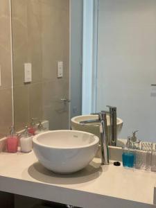 a bathroom with a white bowl sink on a counter at Impactante vista al Río, moderno y con cochera! in Santa Fe