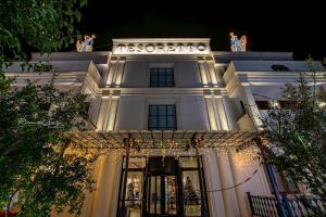 un edificio blanco con luces de Navidad delante de él en Tesoretto Hotel, en Poggiardo