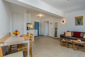 un soggiorno con tavolo e divano di ADAMANTIOS VILLAS & SUITES ad Akrotírion