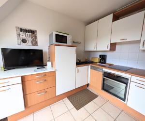 cocina con nevera blanca y microondas en Plage à 300m - Appartement 4 personnes - Parking privé en Pornichet
