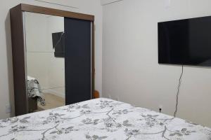 a bedroom with a bed and a flat screen tv at Lindo apartamento centro de Floripa in Florianópolis