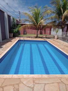 uma piscina azul com azulejos azuis em Chácara do Lele em Ribeirão Preto