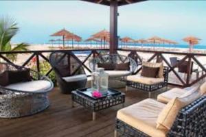 a patio with chairs and tables on the beach at Island Oasis at Tortuga Beach - 487 in Prainha