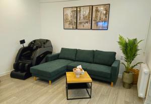 a living room with a green couch and a table at The Bohemian Connection, Rezerva acum studio Ultracentral Spatios si Curat, Scaun Masaj, Ceai, cafea, apa filtru, parcare publica gratuita in Craiova