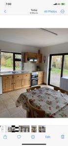 a kitchen with a table and a kitchen with a stove at Westland Apartment No. 1 in Ardea