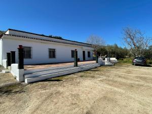 a white building with a car parked in front of it at FINCA SAN RAFAEL in Cabra