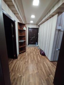 pasillo con puerta y suelo de madera dura en Уютные апартаменты в центре en Tashkent