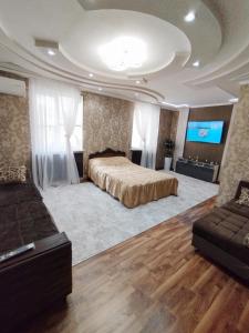 1 dormitorio grande con 1 cama y TV de pantalla plana en Уютные апартаменты в центре en Tashkent
