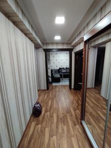 um corredor com pisos de madeira e um quarto com um sofá em Уютные апартаменты в центре em Tashkent