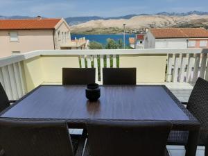 a table and chairs on a balcony with a view at Apartmani Presečki in Pag