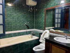 ein Badezimmer mit einer Badewanne, einem WC und einem Waschbecken in der Unterkunft GÁC home & decor in Hanoi