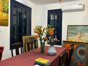 einen Esstisch mit einer Blumenvase darauf in der Unterkunft GÁC home & decor in Hanoi