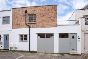 un edificio de ladrillo blanco con dos puertas de garaje en Contemporary 2 Bed Home in Lansdown en Cheltenham