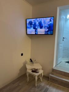 a flat screen tv hanging on a wall with a table at Skadarska in Pančevo