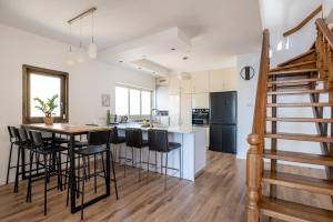 a kitchen with a table and bar stools at Roof Top 3 Floors in Netanya