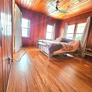 ein Schlafzimmer mit einem Bett in einem Zimmer mit Holzwänden in der Unterkunft Home Sweet Home in Hallandale Beach
