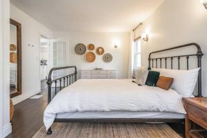 a bedroom with a large bed with white sheets at Boho Inspired NOTL Wine Country Private Home for 2 in Niagara-on-the-Lake