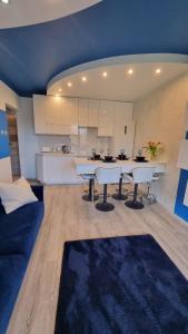 a living room with a couch and a kitchen at BLUE APARTMENT in Polanica-Zdrój