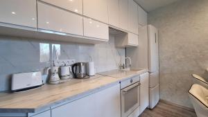 a kitchen with white cabinets and a counter top at BLUE APARTMENT in Polanica-Zdrój
