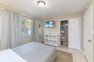 a bedroom with a bed and a flat screen tv at Walk Pompano Beach From Our Cozy One Bedroom Apt in Pompano Beach