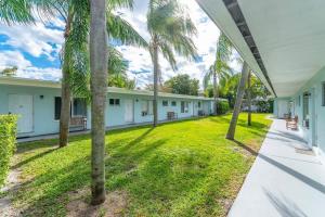 a row of houses with palm trees in the yard at Walk Pompano Beach From Our Cozy One Bedroom Apt in Pompano Beach