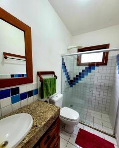 a bathroom with a sink and a toilet and a shower at Paraíso Tropical desejado Centro de Arraial in Arraial d'Ajuda