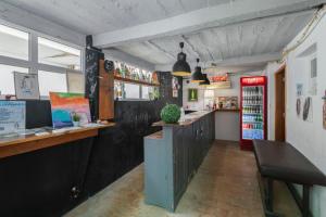 eine Bar in einem Restaurant mit einer Theke und einem Kühlschrank in der Unterkunft Le Penguin Hostel in Faro