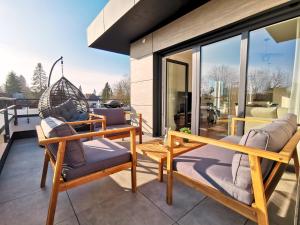 a patio with two chairs and a swing at Fynbos Deluxe, Penthouse oder Balkon, Parkplatz in Straubing