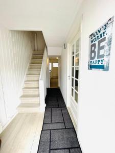 a hallway with stairs and a sign that says yours worthy be happy at Central Economic Stavanger Kongsteinsgata in Stavanger