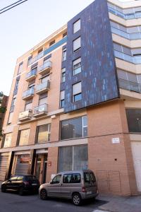 un edificio con dos coches estacionados frente a él en Castellon Ribalta Apartments - Parking disponible, en Castellón de la Plana