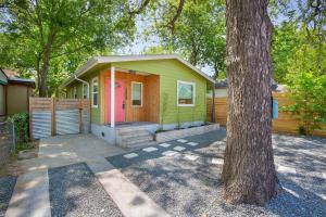 a small green house with a pink door next to a tree at 2 BR 3 BD Popular House by Austin Downtown and 6th Street in Austin