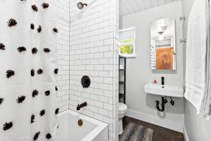 une salle de bain blanche avec une baignoire et des toilettes dans l'établissement Holiday Pool Retreat by Downtown- Lake & Dining Just Steps Away, à Austin 37 autres photos