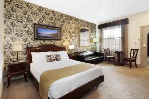 a hotel room with a large bed and a large window at Quality Inn Heritage on Lydiard in Ballarat