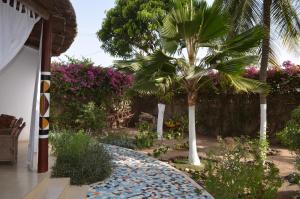 a garden with a palm tree and flowers at Villa Mandel Nafio, Haus mit Garten nahe dem Atlantik in Ouoran
