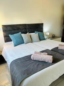 een groot wit bed met 2 handdoeken erop bij Spacious and Cozy Apartment near St Julians - Short Let Apartments Malta in Is-Swieqi
