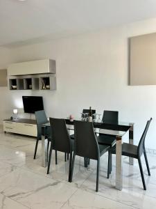 une salle à manger avec une table et des chaises noires dans l'établissement Spacious and Cozy Apartment near St Julians - Short Let Apartments Malta, à Is-Swieqi