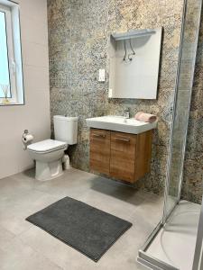 een badkamer met een toilet, een wastafel en een douche bij Spacious and Cozy Apartment near St Julians - Short Let Apartments Malta in Is-Swieqi