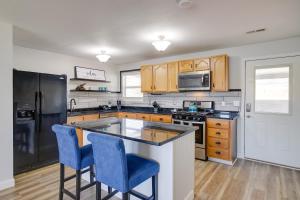 a kitchen with wooden cabinets and blue bar stools at Waterfront Kingston Apartment with River Access! in Kingston