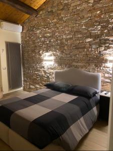 Ce lit se trouve dans un dortoir doté d'un mur en pierre. dans l'établissement DOLCE VITA, à Vignanello