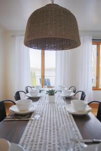 mesa de comedor con sillas y una gran lámpara de araña. en 4 br Lakehouse, Fire Pit, King Beds, Bunk room, en Lake Orion