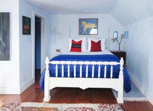 Eileen of Mystic في ميستيك: غرفة نوم مع سرير مع الوسائد الحمراء والزرقاء