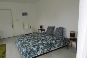 - une chambre avec un grand lit et 2 tables dans l'établissement Chambre 20m2 avec salle de bain privée dans maison en bois, à Lavaur