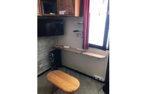a room with a wooden stool and a television at Résidence quartier Hauts-Forts - Maeva Particuliers - Studio 4 Personnes Confort - Le Pas du Lac 124223 in Morzine