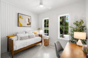 a bedroom with a bed and a desk and windows at Casa Cohiba - Ybor City Townhouse in Tampa