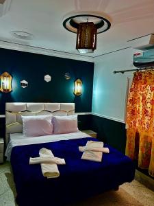 a bedroom with a bed with towels on it at Hôtel Riad Atlas Dades in Boumalne