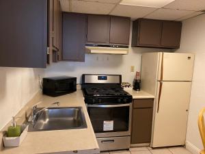 a kitchen with a stove and a sink and a refrigerator at Carmel Resort Inn in Carmel