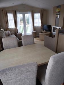 a living room with a wooden table and chairs at Cordy's Caravan in Mablethorpe