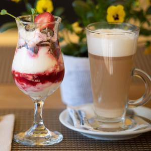 two glasses of ice cream and a cup of coffee at Viesnīca Kandava in Kandava